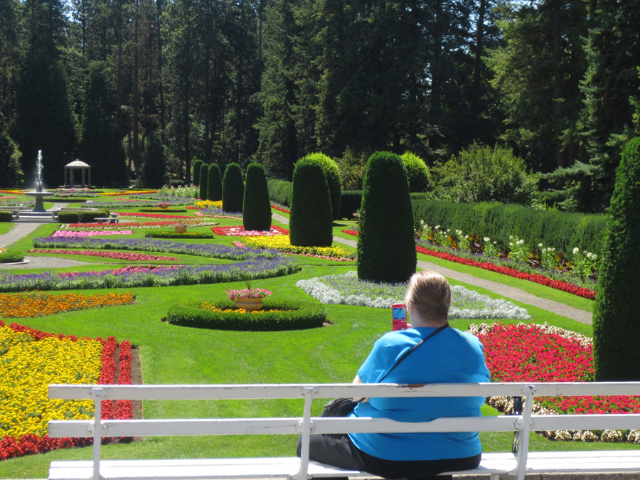 Women taking picture of formal garden.